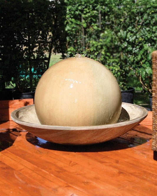 Outdoor water fountain featuring a ball and wok design.