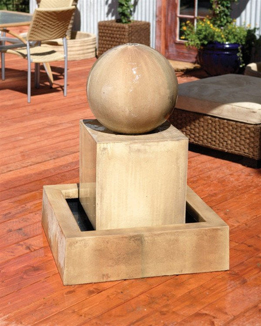 Garden fountain with a sphere on a block.