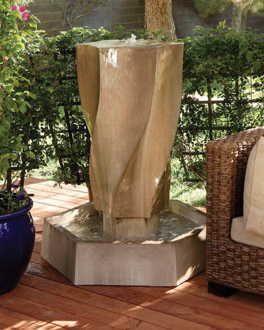 A large, modern outdoor water fountain with a swirling, vortex-like design.
